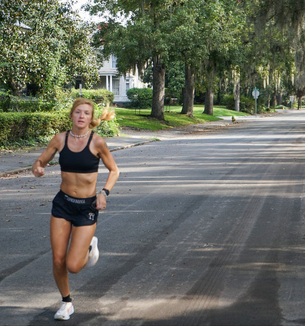 Woman running on a tree-lined street