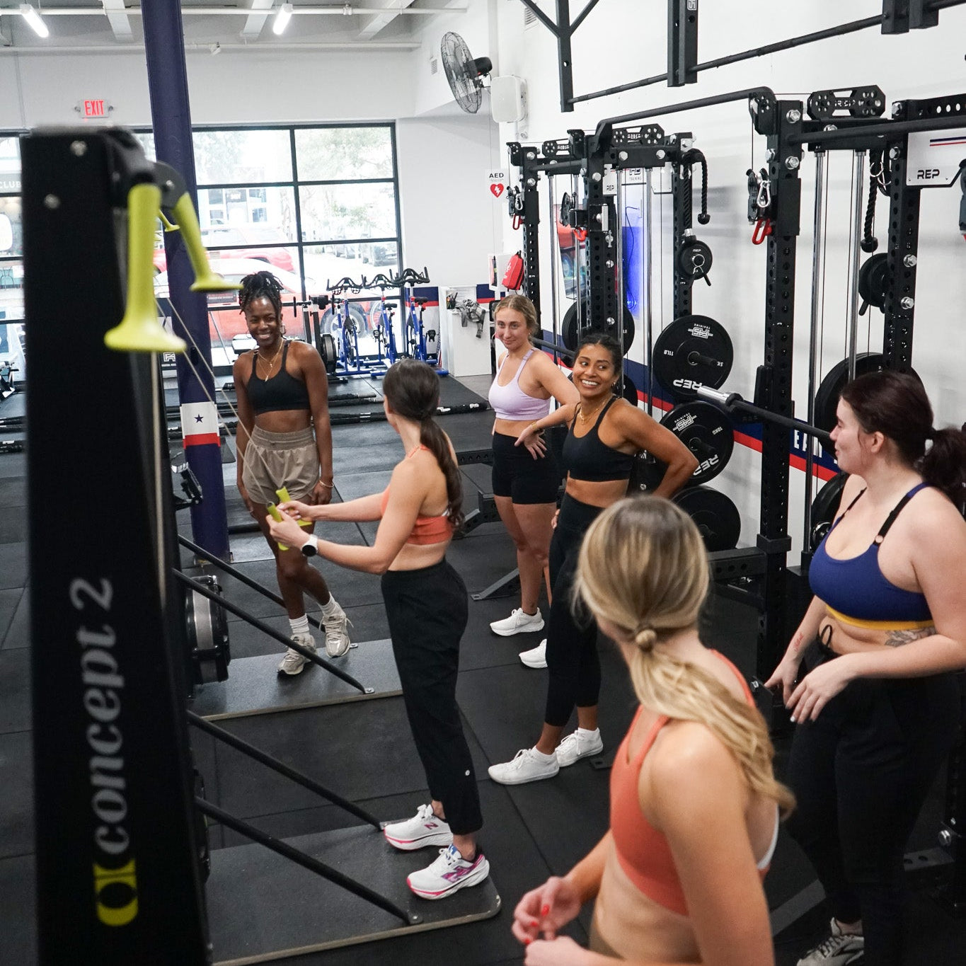 Group of women exercising on a Concept 2 machine in a gym setting